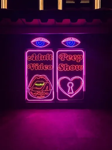 Neon signs on a dark wall at The Iron Fairies