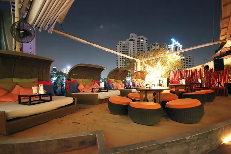 Nest's rooftop terrace with cabanas and city views at night
